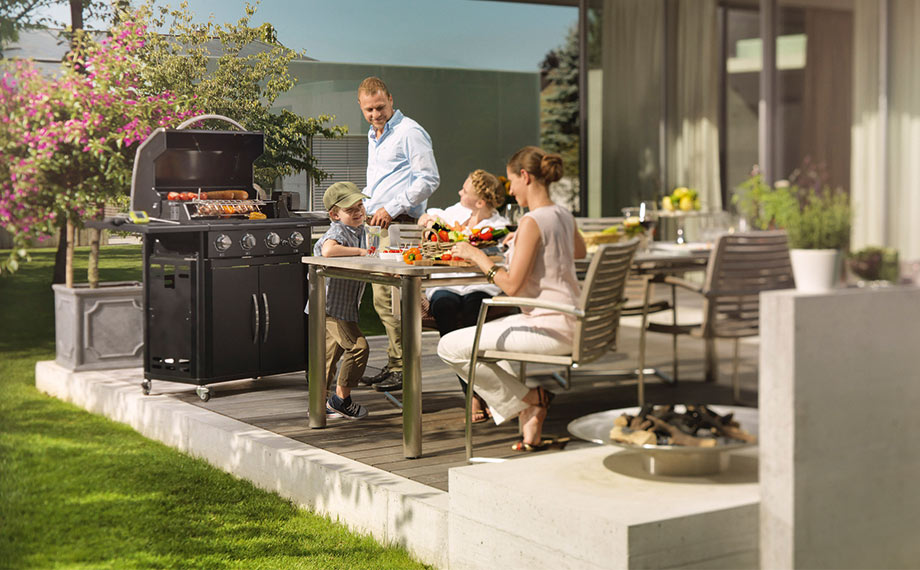 Eine Familie grillt auf einer Holzterrasse von Holzland Beese in Unna.