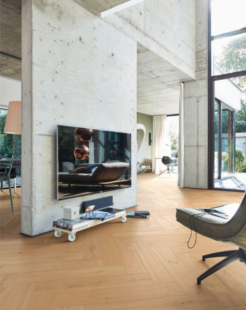 Weiträumiger Wohnbereich im Industrial Style mit Betonwänden und Lindura von Beese