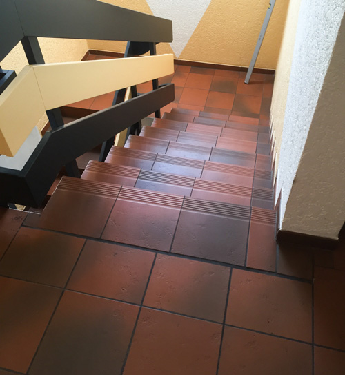 Treppe mit alten Fliesen und einem Geländer | HolzLand Beese Unna