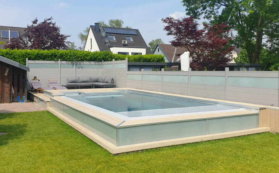 Helle WPC-Terrassendielen verleihen der Poolumrandung modernen Charme, Sichtschutz im Hintergrund schafft eine geschützte Atmosphäre, HolzLand Beese Unna