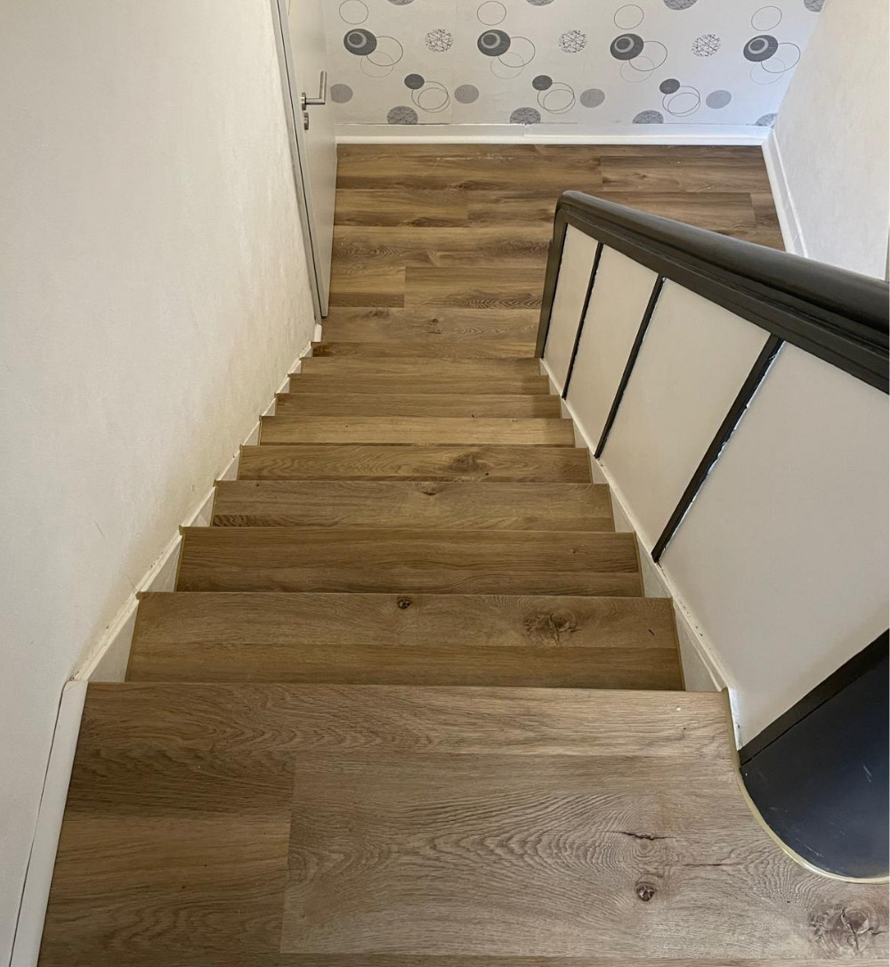 Durchgehend gestaltetes Treppenhaus: Fußboden und Treppe mit Eichen-Vinylbelag, HolzLand Beese Unna